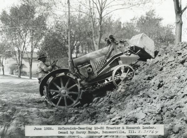A man, possibly Harry Runge, uses a McCormick-Deering 10-20 tractor and Monarch loader on a large pile of dirt.