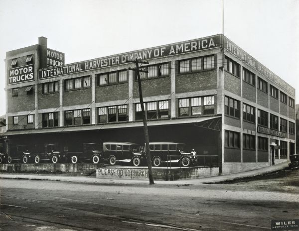 Exterior view of the International Harvester Company Nashville branch warehouses and offices. Several trucks are parked on a loading dock along the side of the building.