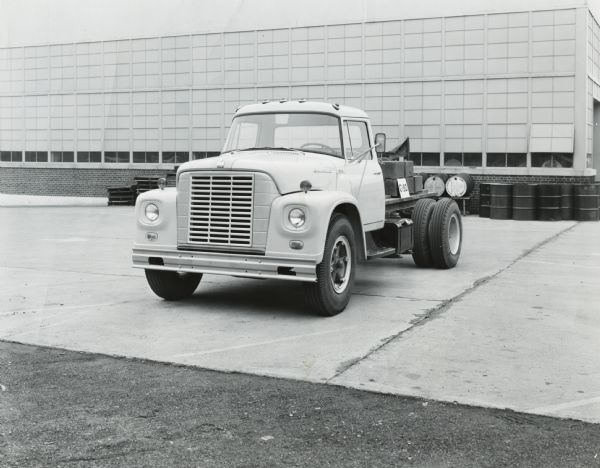 Three-quarter front view of an International Loadstar truck parked in front of a factory building.