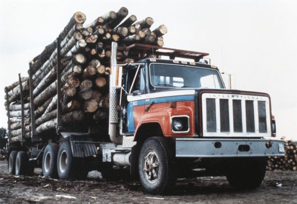 Three-quarter front view of an International heavy S-1 truck loaded with logs.