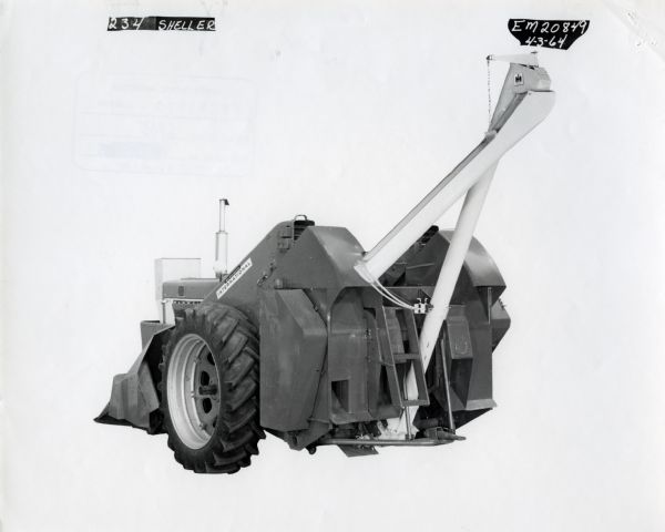 Three-quarter rear view of a McCormick International Number 234 corn harvester in a studio against a white backdrop. The text at top reads: "234 Sheller" and "EM20849. 4-3-64."