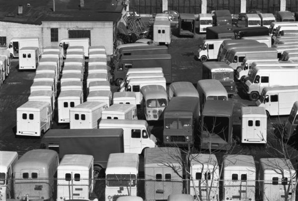 Elevated view of International Metro trucks in a parking lot beside factory buildings.
