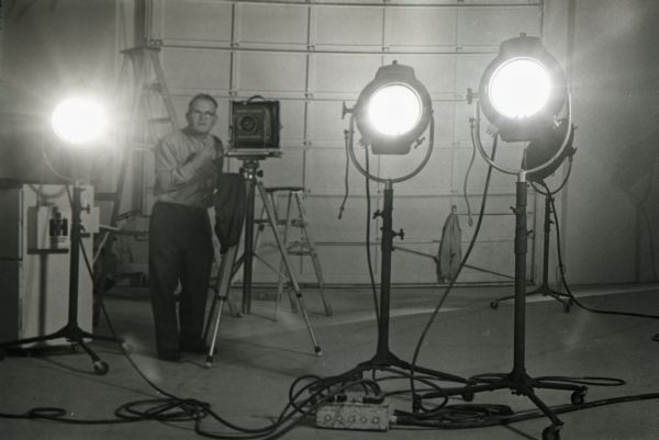 A man adjusts a camera in the film and photography studio at International Harvester's Hickory Hill Farm.