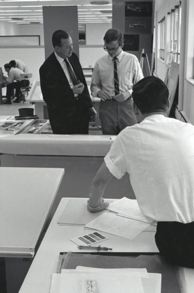 IH engineer Ted Ornas consults with a student in International Harvester's first styling seminar at the Fort Wayne motor truck engineering department. Another man sits on a drafting table in the foreground. The program lasted ten weeks and participants were college students in their junior year, presented with the challenge of designing a "Multipurpose Safety Utility Vehicle."