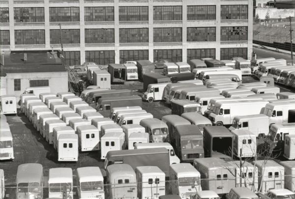 Elevated view of Metro trucks and Metro-Mites parked bumper to bumper in an outdoor lot at the Metropolitan Body company, an International Harvester subsidiary.