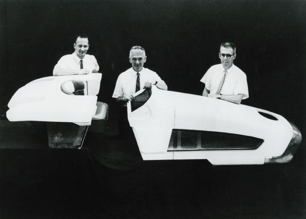 Three men, most likely IH engineers, posing for a studio portrait with an International Harvester model HT-340 research tractor.