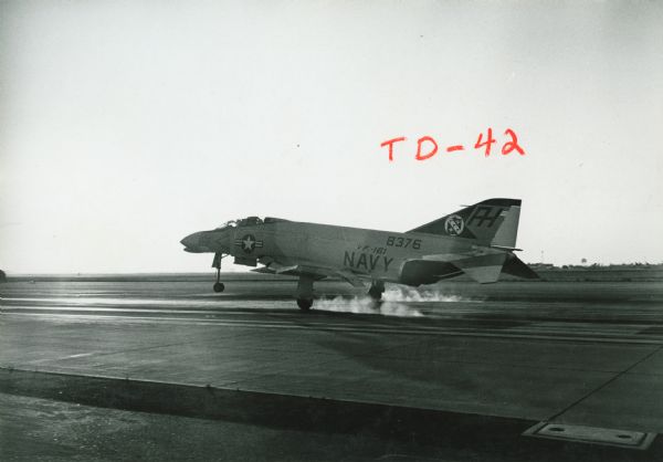 Side view of a Navy plane marked with "8376" and squadron number "VF-161" on a tarmac at Miramar Naval Air Station. Written on the photograph in grease pencil is "TD-42."