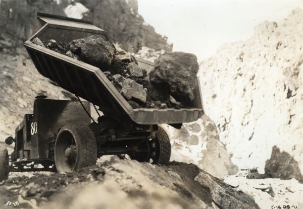 Rear view of an International dump truck loaded with boulders blasted from the sides of a canyon during the construction of the Hoover Dam.