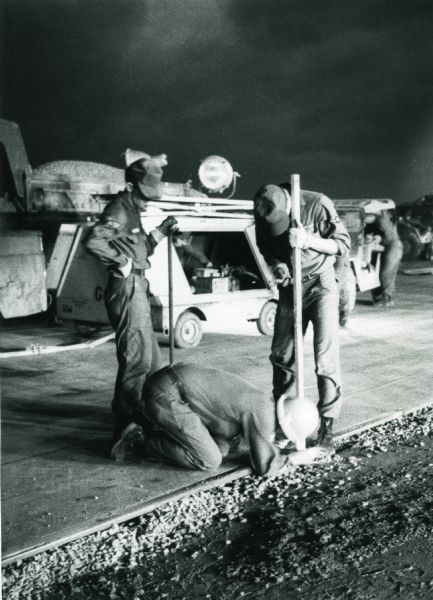 Three men work at night to construct a runway at Phan Rang, a South Vietnam air base.