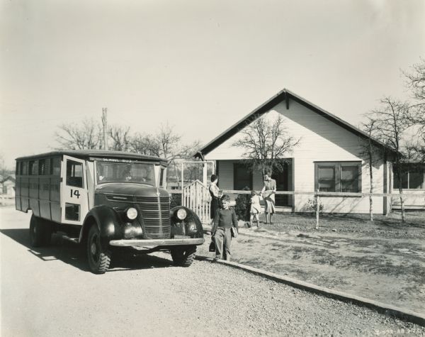 Children are leaving home to board an International D-35 bus to school. The bus was equipped with a Picayune body with 179-inch wheel base.