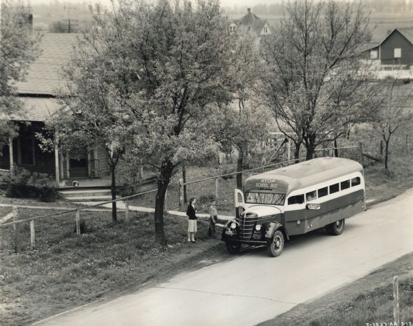 Elevated view of two children boarding an International D-3 bus with a 19 foot Hicks body.
