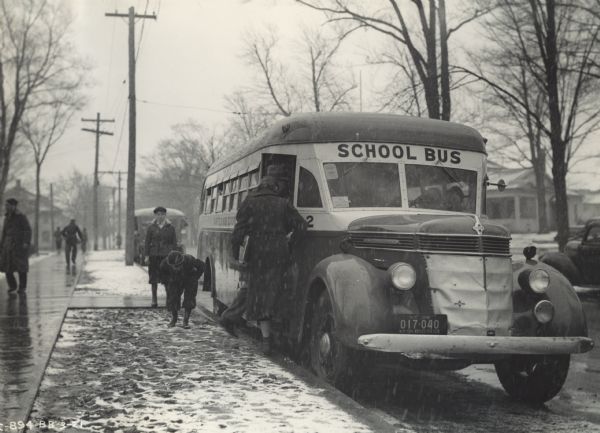 International D-40 bus picking up school children in a residential neighborhood on a snowy day. The bus was equipped with a 235-inch Rex-Watson 49 passenger body.