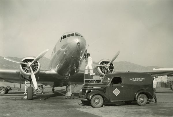 Original caption: "A D-2 panel truck (125" WB) owned by Railway Express Agency of this city [Los Angeles, California]. Used by the Air Express Division. Unloading into one of the new TWA Skysleeper planes at the Union Air Terminal near Burbank [California]."