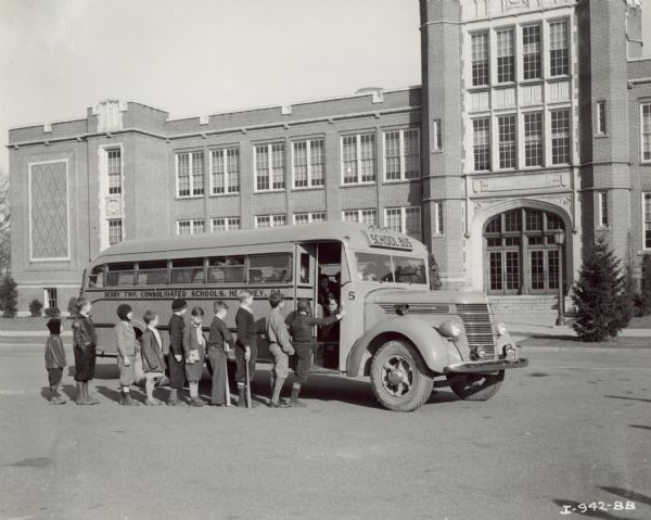 Students in line to board the International D-40 bus in front of a Derry Township consolidated school, in or near Hershey, Pennsylvania. A few of the students have baseball bats. The bus was equipped with a 215-inch wheel base and a Superior Body.