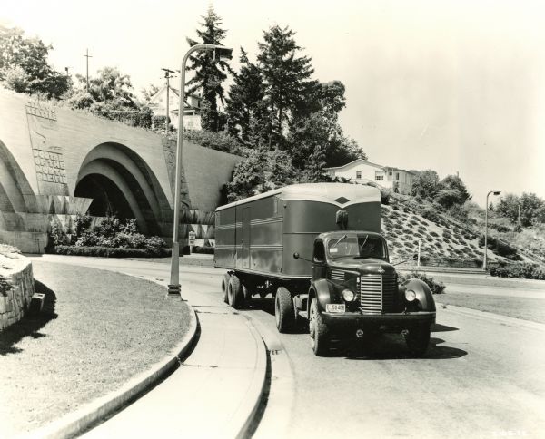International KR-11 truck with semi-trailer on an urban road. A tunnel is in the background with lettering that welcomes visitors to Seattle.