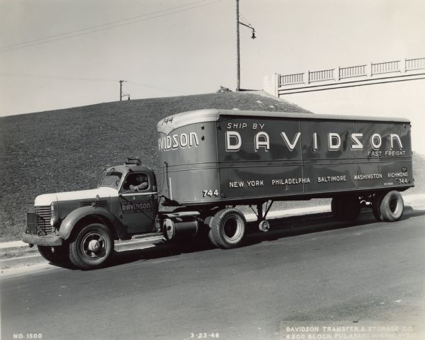 Man driving International truck with semi-trailer owned and operated by Davidson Fast Freight, a division of Davidson Transfer & Storage Company.