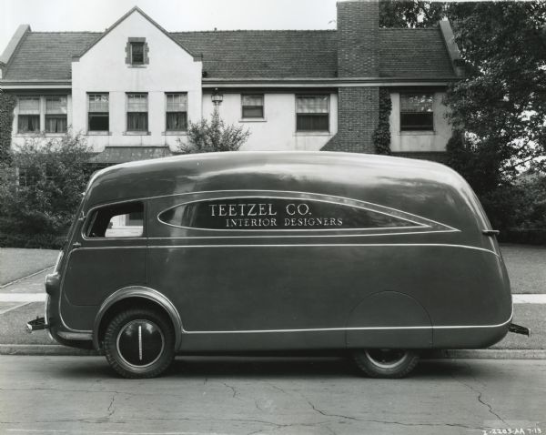 An International D-30 truck owned by Teetzel Company Interior Designers parked outside a residence.