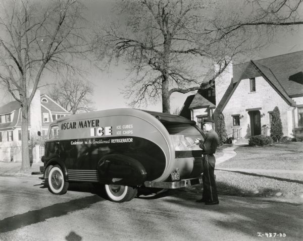 A man uses tongs to remove a block of ice from the back of an International D-300 owned by the Oscar Mayer Company as he makes a delivery to 150 Lakewood Boulevardd, Maple Bluff.  The home was owned by Jack Reynoldson, an Oscar Mayer employee.