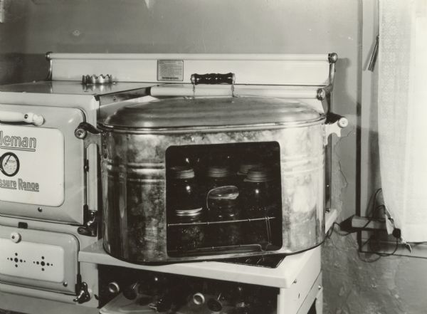 Fake boiler showing glass jars for canning. Original caption reads: "Draw line to show water line when canning with hot water." This photograph was taken at the Harvester Farm.