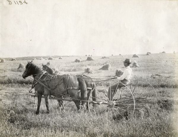 Man Operating Hay Rake in Field | Photograph | Wisconsin Historical Society