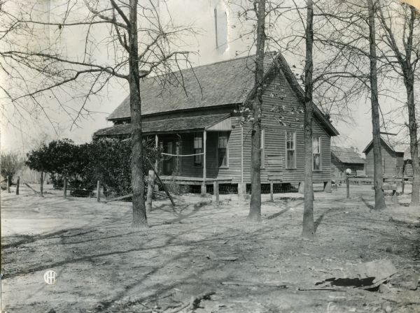 Farmhouse with a porch in front and farm buildings in the back. Thee is a fence around the farmhouse yard. Original caption reads: "Seven room house of S. Tindeal, (colored). Shows comfortable home won by hard work & straight dealings. He owns 200 acres worth $50 an acre. He practices rotation but raises cotton mostly."