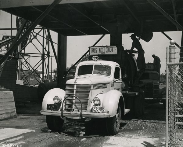 An International D-246-F truck owned by Transit Mixed Concrete Company Inc. parked beneath a bridge. The truck is outfitted with a Jaeger 3 1.2 cubic yard truck-transit concrete mixer.