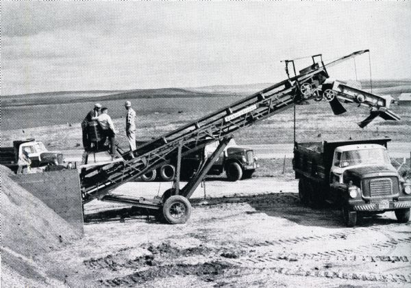Trucks and equipment from G.H. Lindekugel & Sons work to construct a highway.