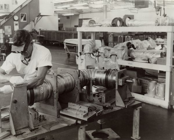 Worker at the Solar Division of International Harvester works on components for the Saturn rocket. Original caption reads: "A Solar craftsman puts some finishing touches on a section of ducting for the huge Saturn rocket which has propelled U.S. astronauts to the moon. Solar-built components and systems are in every stage of NASA's Saturn/Apollo program."