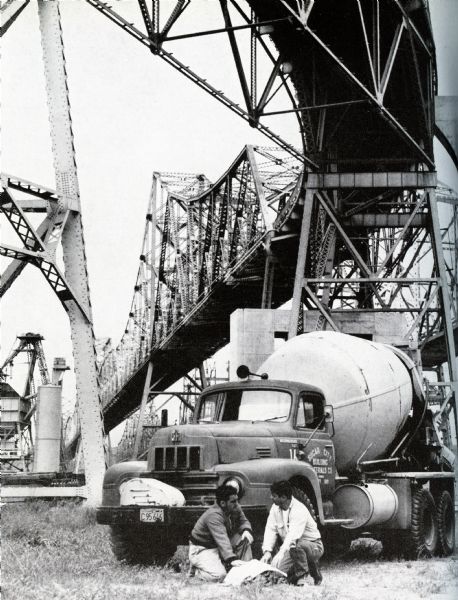 Peter Guerrieri and John Balmino of Sugar City Building Materials Company sit beneath the Carquinez Bridge in front of an International cement mixer.