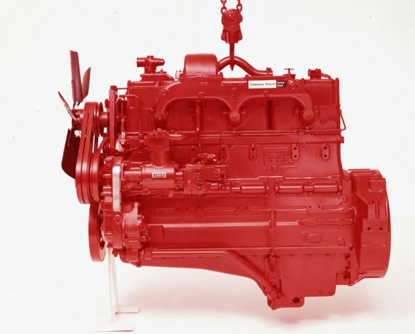 Color photograph of a red Cummins diesel engine set against a white background. The engine was used in International trucks.