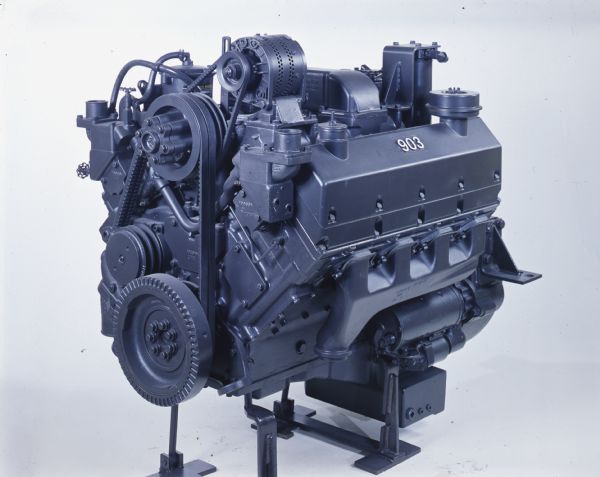 Color photograph of a Cummins engine marked 903 and set against a white background.