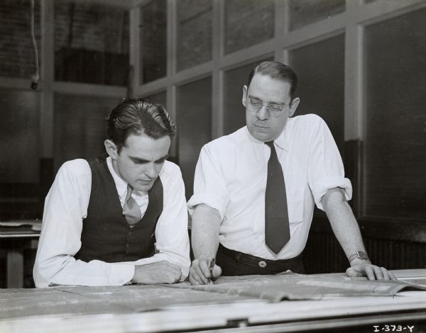 D.G. Renno (left) and H.K. Reinoehl look over blueprints in the Engineering Department at International Harvester's Ft. Wayne Works.