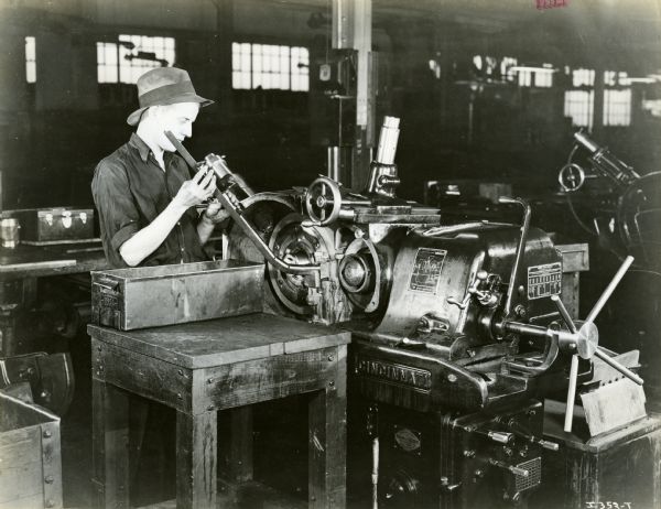 Factory worker grinding piston pins for truck engines at International Harvester's Ft. Wayne Works. The grinder was manufactured by Marshall & Huschart.