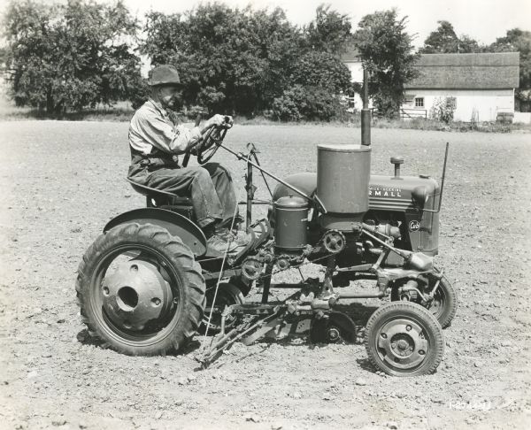 Alfred Schlepman uses a Farmall Cub tractor outfitted with a 172 A one-row runner planter with a edge drop hopper.