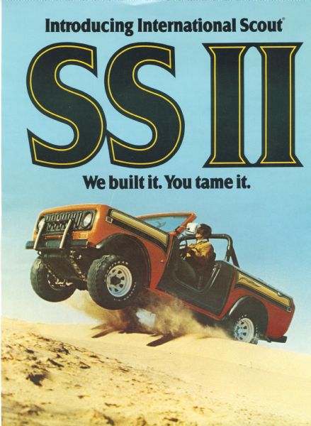 Cover of a sales brochure for the International Scout. The cover features a man driving a red, black, and tan Scout which is airborne over a sand dune. Cover reads: "Introducing International Scout SS II" and "We built it. You tame it."