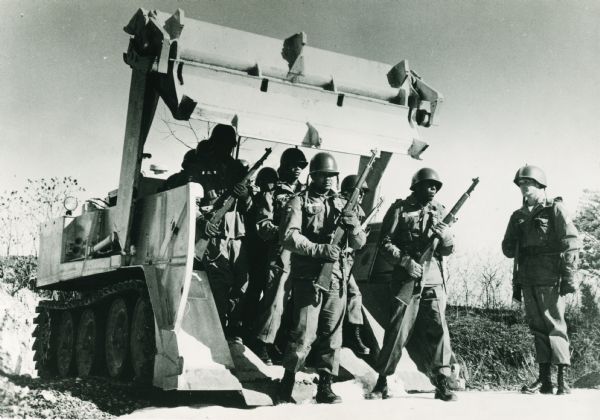 The original caption reads: "Primary mission for the army's present personnel carrier is just one possible assignment for the UET-E1. The 10-man Combat Engineer Squad is transported easily, comfortably, to front line, bridge emplacement, earthwork assignment, or air field construction site at speeds up to 30 mph. Their combat equipment moves with them. This capability reduces the need for personnel carriers. One-man operation of all driver functions is simple and easily learned."