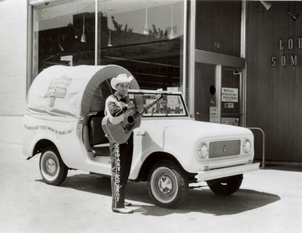 International Cudahy Packing Co. Scout. Original caption reads: "Photograph No. MQ-303-- A New International Scout gets into the act with the Cudahy Cowboy, radio and television entertainer. The vehicle was recently purchased by Cudahy Packing Co. to be used in an advertising and sales promotion campaign in the Omaha, Neb., area. It has its own sound system enabling the cowboy to do on-the-spot shows at supermarket parking lots, schools, 'covered wagon' is said to attract a great deal of attention wherever it goes. The driver's compartment is equipped with removable steel top and removable doors, standard on all Scout models. MT-2256. CR-1146-D."