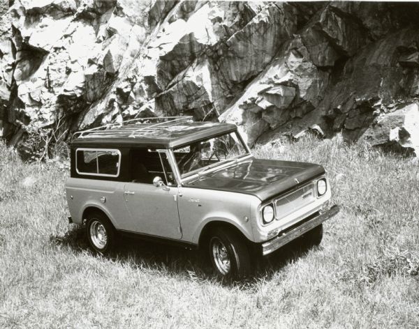 International Harvester Aristocrat Scout. Right-front view. Original caption reads, "Photograph W-6098-- Low profile wide oval tires are featured on the all-wheel drive International Scout Aristocrat. Proving-ground and field trials have demonstrated the practicality of the Aristocrat's big footprint H70-15 tires on their seven-inch-wide rims. Excellent roadability is combined with dependable rough-going characteristics and four-wheel traction. MT-3314."
