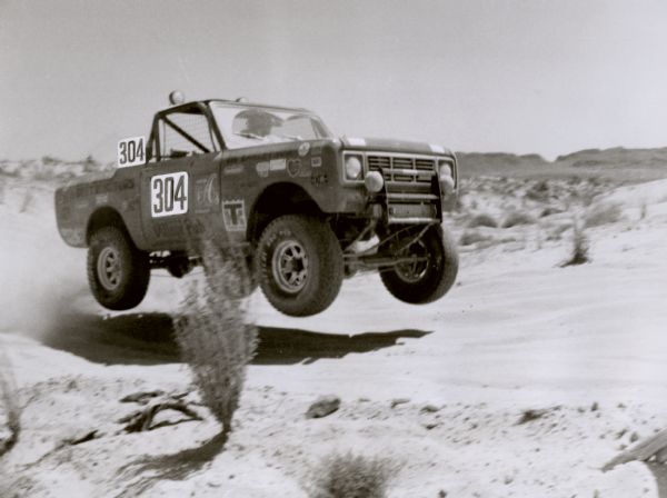 International Scout places 5th at "Baja 500." Original caption reads: "(Photo #tf 1402) Jimmy Jones, El Cajon, Calif., in his International Scout II, finds himself temporarily airborne at the "Baja 500" - an off-road racing classic sponsored by SCORE and run over some of North America's most punishing terrain. More than 80 percent of the vehicles entered eventually wind up strewn over the 500-mile course but Jones drove his Scout to a strong finish in the stock vehicle class."