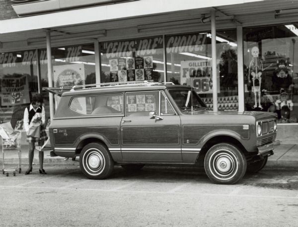 Original caption reads: "Photo #TF-1203. International Scout for 1975 is equally at home at the supermarket as it is in rugged backcountry.  The go-anywhere vehicle is available with optional vinyl applique including stripes, color panels and wood grain. Automatic transmission, power steering, power brakes and air conditioning are a few of the available options. TD-3763a. 10/1/74."