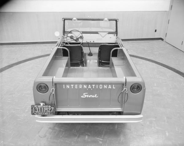 View from behind of a 1963 model year 4x2 Scout with the production Walk-Thru conversion and the production bucket seats. It is parked indoors.