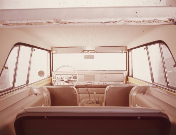 Interior view of International Scout 800 from the far back, showing two front seats and a back bench seat.
