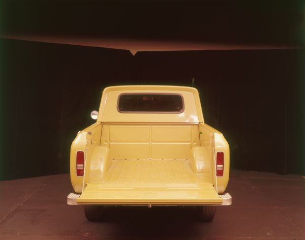 Rear view of yellow Scout II pickup with tailgate open.