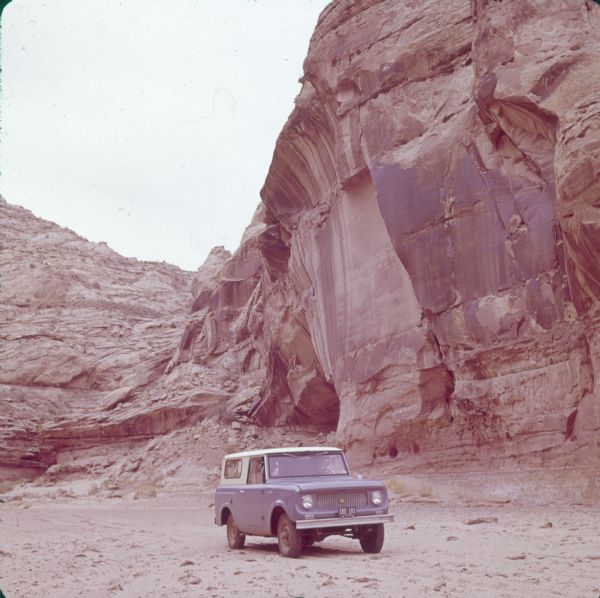 1961 Scout 80 makes its way through dry creekbed in Canyonlands.