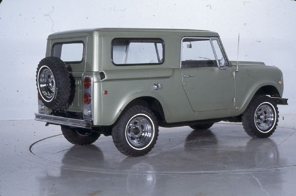 Three-quarter view from rear of passenger side of green International Aristocrat parked indoors. Two doors, spare tire mounted on exterior of rear hatch.