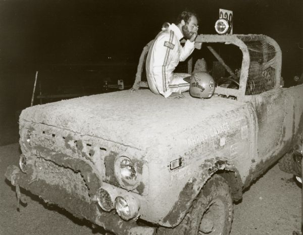 Original caption reads: "Off-road racing is every bit as tough on drivers as it is on vehicles. P.D. Perry, Effingham, IL, savors the initial quiet moments on the hood of his International Scout SS-II after completing a recent 10-hour off-road race near Lake Geneva, WI.  This same vehicle - minus the mud - is on display at the International Scout exhibit at the Chicago Boat, Sports & RV Show, January 4-8, McCormick Place. 1/4/78."