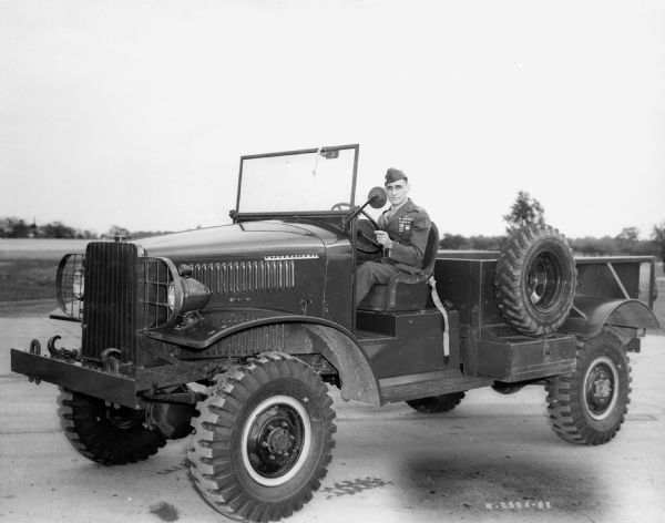Soldier sitting in the driver's seat of an International military vehicle.