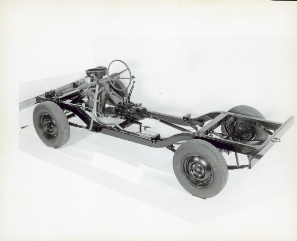 Three-quarter view from rear of driver's side of rolling chassis for a Scout 4x4. Steering wheel and drive train are exposed.