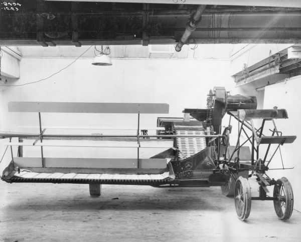Original caption reads: "Deering No. 3 harvester-thresher as first built in 1923. This machine was chain driven instead of gear driven as were the earlier machines. The slatted feeder elevator was a distinguishing feature of this machine as built in 1923. The following year the elevator was replaced by a feed conveyor."