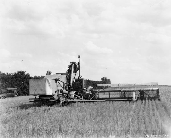 Original caption reads: "No. 9 harvester-thresher as built in 1926. This was a large 16-foot machine and the heaviest harvester-thresher ever built by the Harvester Company. Its principal characteristics were the floating type header platform, drag type feeder, ball bearing cylinder, 4-section straw rack, recleaner, and 60-bushel grain tank located on top of the machine. This machine weighed approximately 10,650 pounds."